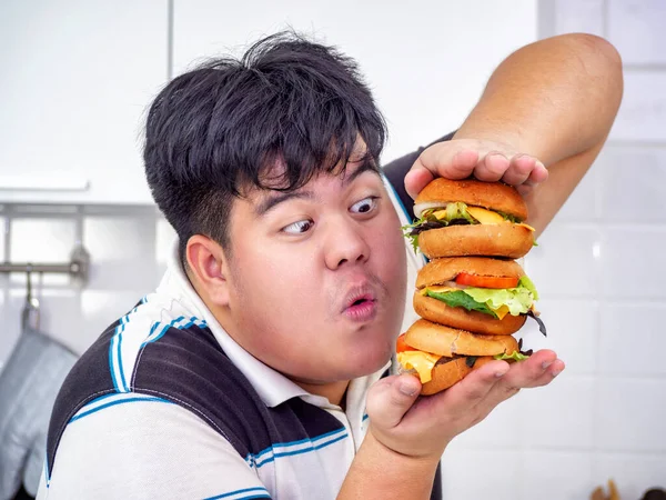 Diet failure of fat man eating fast food unhealthy hamberger.