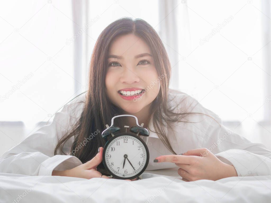 Close up of a happy young woman smile while lying on the bed at home on morning.