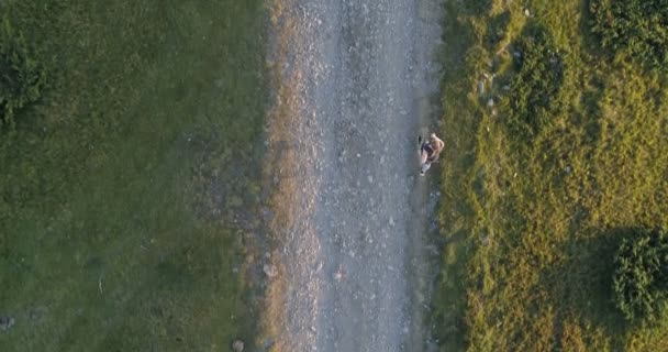 Mujer corriendo en una carretera de campo al atardecer . — Vídeo de stock