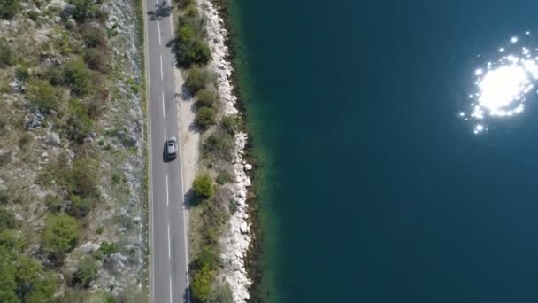 Машина едет вдоль прибрежной дороги над скалистым берегом — стоковое видео