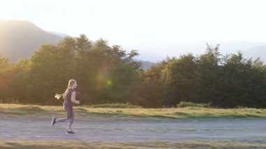 Bir kırsal yolda günbatımında çalışan kadın.