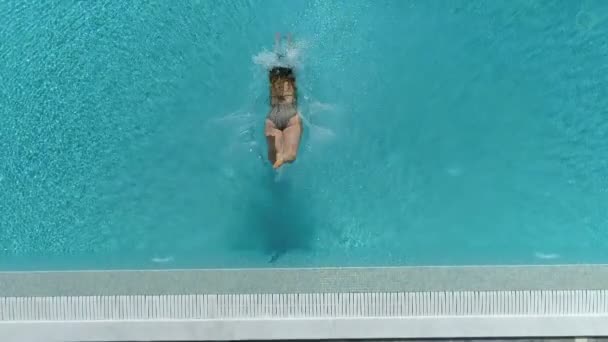 Жінка стрибає в басейн — стокове відео