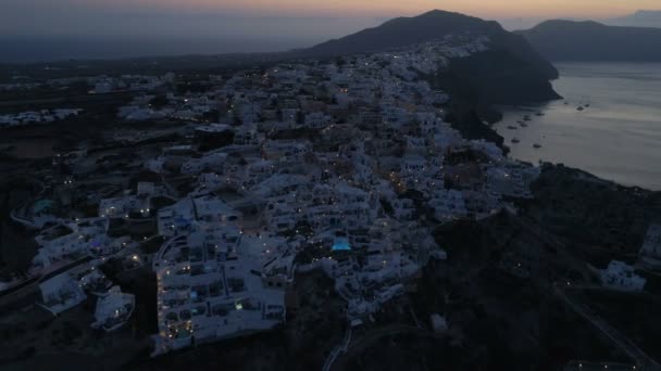 Vista aérea volando sobre la ciudad de Oia en Santorini Grecia — Vídeo de stock