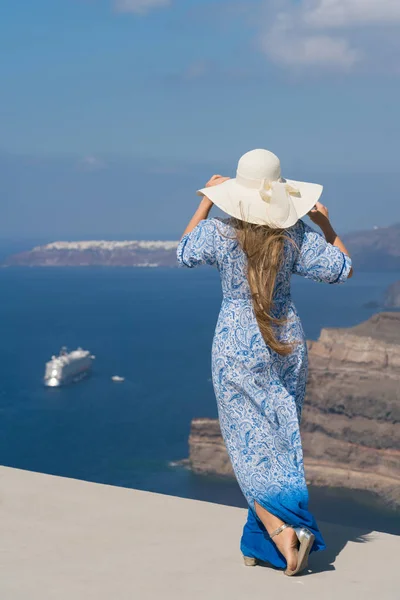 Mladá žena v bílé a modré šaty se těší na procházku po Santorini — Stock fotografie