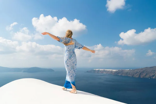 Mladá žena v bílé a modré šaty se těší na procházku po Santorini — Stock fotografie