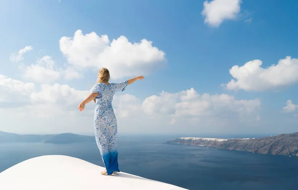 Mladá žena v bílé a modré šaty se těší na procházku po Santorini — Stock fotografie