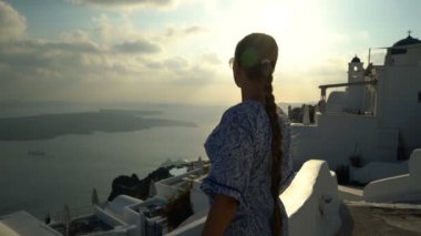 Santorini, Yunanistan onun tatil zevk beyaz ve mavi elbiseli mutlu kadın. Caldera ve Ege Denizi üzerinden Imerovigli görüntüleyin. Etkin, seyahat, turizm kavramları