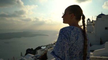 Santorini, Yunanistan onun tatil zevk beyaz ve mavi elbiseli mutlu kadın. Caldera ve Ege Denizi üzerinden Imerovigli görüntüleyin. Etkin, seyahat, turizm kavramları