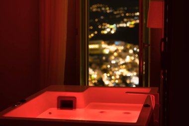 Lüks seyahat Santorini tatil otel Jakuzi şehrin gece manzaralı renkli ışıklar ve.