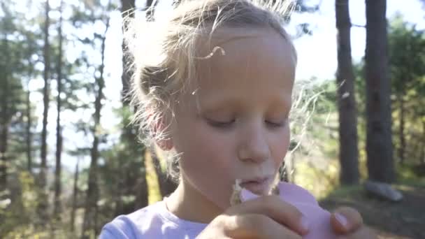 Close-up van portret van een mooi jong meisje te genieten en eten van een verse boterham tijdens een zomervakantie. — Stockvideo