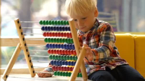 Мальчик в детском саду играет с абакусами — стоковое видео