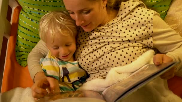 Μαμά Και Μωρό Γιος Διαβάζοντας Ένα Βιβλίο Στο Κρεβάτι Πριν — Αρχείο Βίντεο