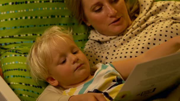 Mère et bébé fils lisant un livre au lit — Video