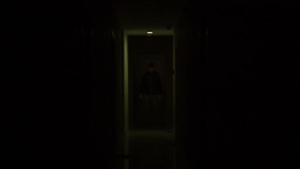Μια σιλουέτα εμφανίζεται και εξαφανίζεται σε ένα σκοτεινό, φοβισμένοι διάδρομο — Αρχείο Βίντεο