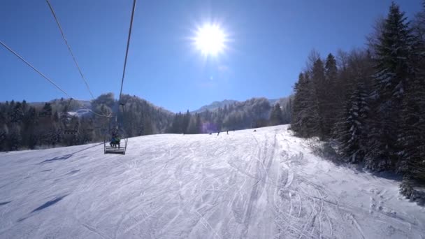 Bosque de nieve y esquiadores en un telesilla pov — Vídeos de Stock