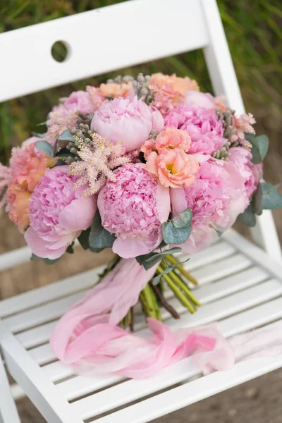 Свадебный букет из розовых пионов, связанных лентами — стоковое фото