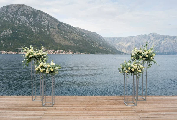 Moderne stands met bloemen op de achtergrond van de zee voor de huwelijksceremonie — Stockfoto