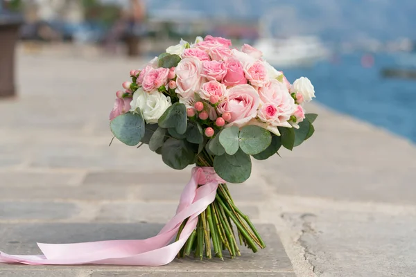 Rosa-weißer Hochzeitsstrauß steht auf einem Steg am Meer — Stockfoto