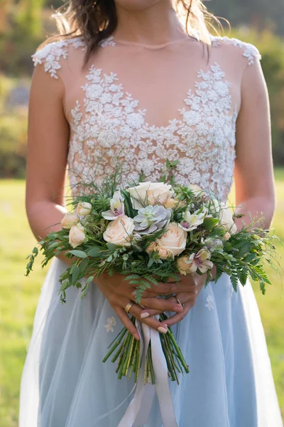 La novia está sosteniendo un ramo de boda rústico con suculentas flores y vegetación — Foto de Stock