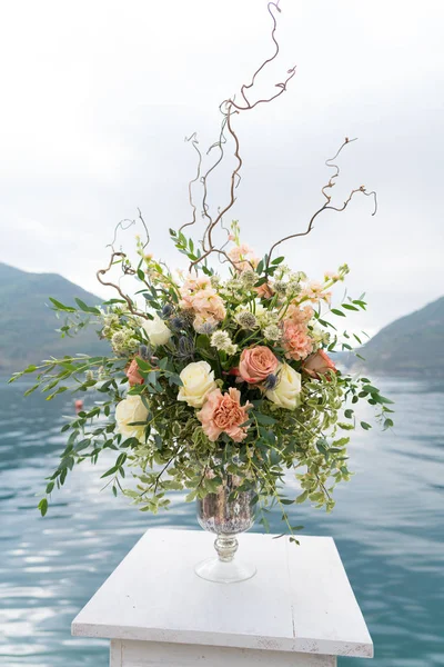 Arreglos florales en soportes para una ceremonia de boda en el muelle contra el mar — Foto de Stock