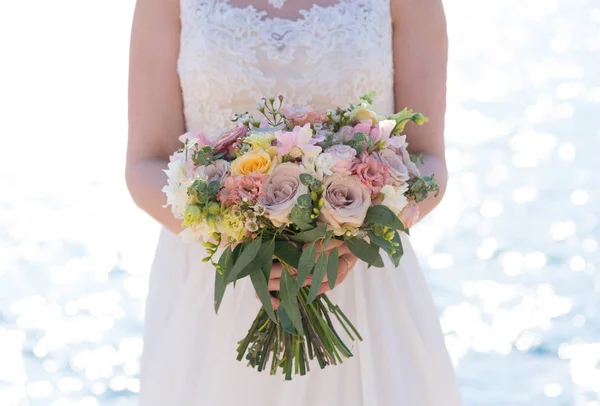 Bride holds a pink wedding bouquet of various flowers and eucalyptus — Stock Photo, Image