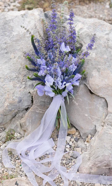 Elegante ramo de flores y hierbas púrpuras se levanta contra una piedra — Foto de Stock