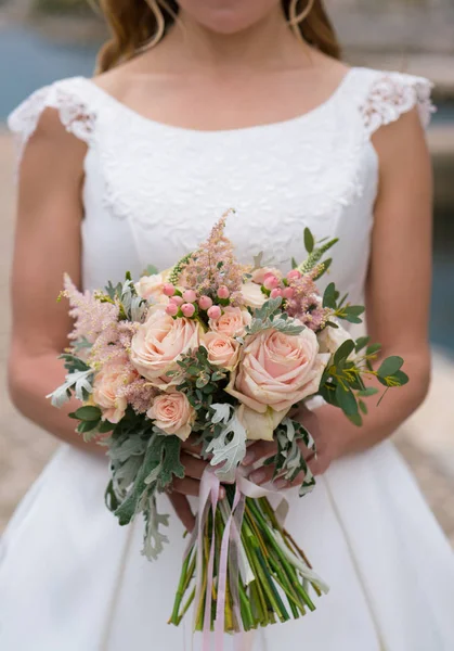 A noiva mantém um buquê de casamento rosa-pêssego — Fotografia de Stock