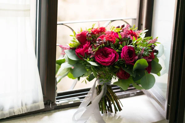 Ramo de flores y eucaliptos frescos de color rojo brillante en el alféizar de la ventana — Foto de Stock