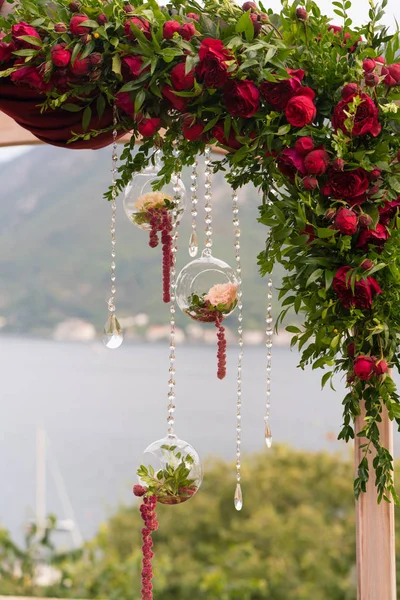 Arco decorado con flores frescas en tonos rojo oscuro para la ceremonia de la boda — Foto de Stock