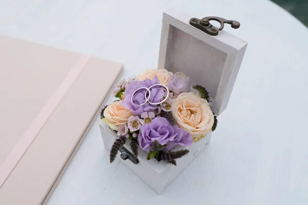 Ataúd con anillos de boda y flores frescas para la ceremonia — Foto de Stock