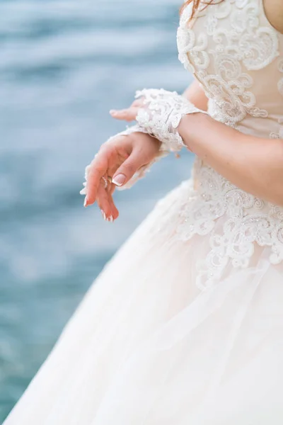 Sposa sullo sfondo del mare in un abito da sposa bianco e guanti sulle mani — Foto Stock