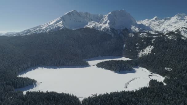 Letecká zimní pohled na sněhu zahrnuty Černé jezero v národním parku Durmitor hory — Stock video