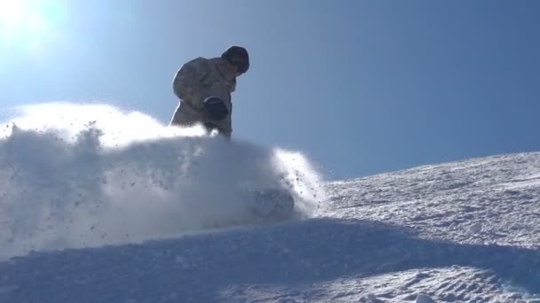 Snowboardista brzdy zvednutím sněhová fontána do vzduchu — Stock video