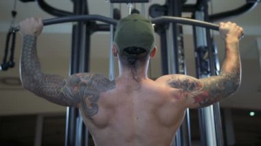 adam spor salonunda latissimus dorsi lat pulldown makine tarafından eğitiyor.