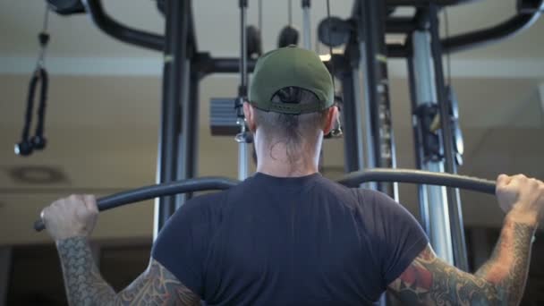 Man in de sportschool treinen de latissimus dorsi door de lat pulldown machine — Stockvideo