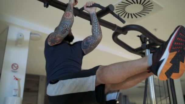 Man in een sportschool benen horizontaal houden omhoog te trekken — Stockvideo