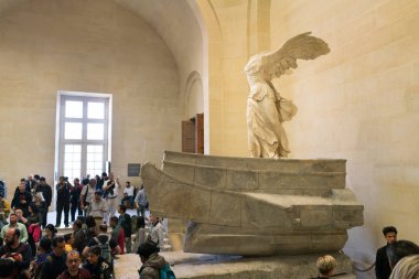 Paris, France - March 31, 2019: People on stairs look at The Winged Victory of Samothrace. clipart