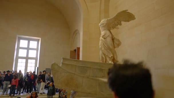 Paris, France - March 31, 2019: People on stairs look at The Winged Victory of Samothrace. — Stock Video