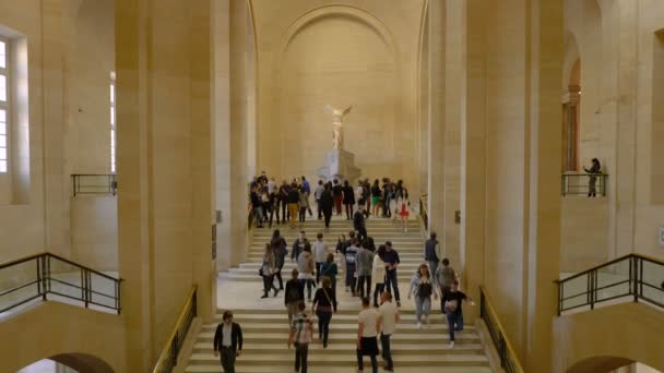 Paříž, Francie-31. březen 2019: lidé na schodech se dívejte na okřídlené vítězství Samothrákie. — Stock video