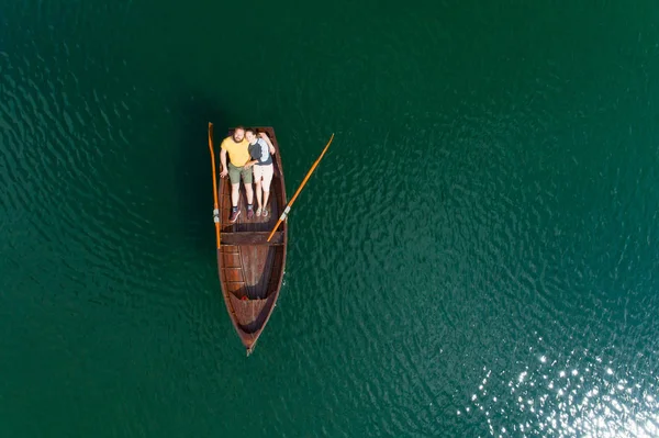 Jeune couple dans un bateau sur le fond d'un lac . — Photo