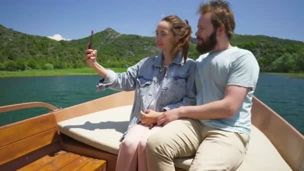 Ζευγάρι απολαμβάνοντας ένα μηχανοκίνητο σκάφος βόλτα στη λίμνη και κάνοντας μια βιντεοκλήση — Αρχείο Βίντεο