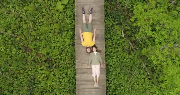 couple d'amoureux couchés sur un pont en bois dans la forêt 