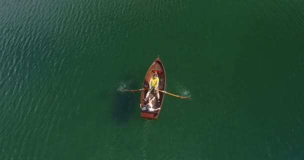 Casal jovem em um barco no fundo de um lago . — Vídeo de Stock