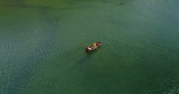 Casal jovem em um barco no fundo de um lago . — Vídeo de Stock