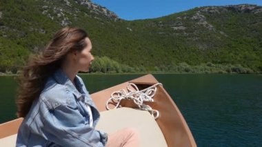 Genç kadın bir motorlu tekne oturur ve güneşli bir günde bir binmek sahiptir