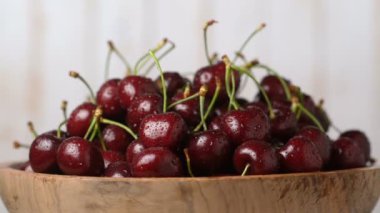 Ahşap bir kapta taze, olgun, sulu kiraz, rotasyon zoom. Gıda arka plan.