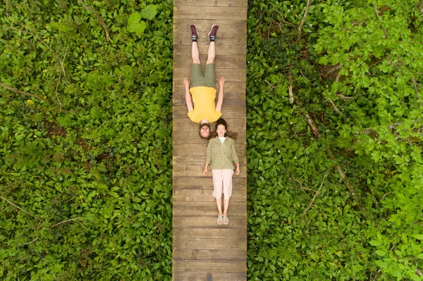 Coppia di innamorati sdraiati su un ponte di legno nel bosco — Foto Stock