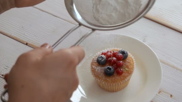Şef çilek ile süslenmiş pudra şekeri cupcake serpilir — Stok video