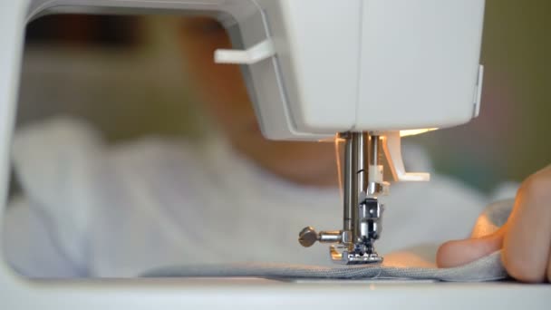 Seven year old girl sews at home on a sewing machine — Stock Video