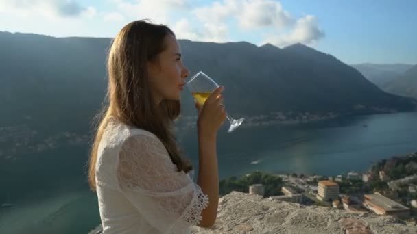 Menina bebe vinho ao estar acima de Kotor — Vídeo de Stock